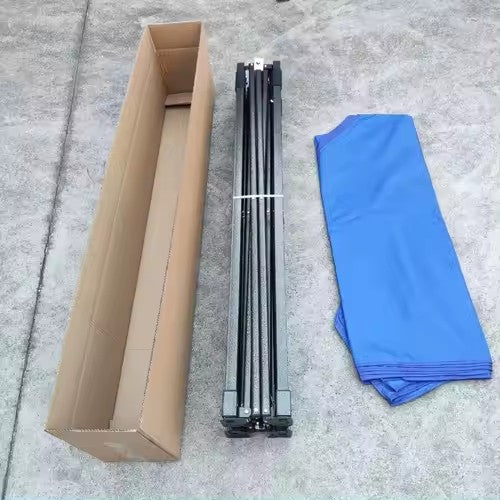 Cardboard box, black metal rods, and blue cloth on a concrete surface