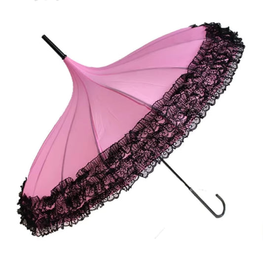 Pink umbrella with black lace trim on a white background